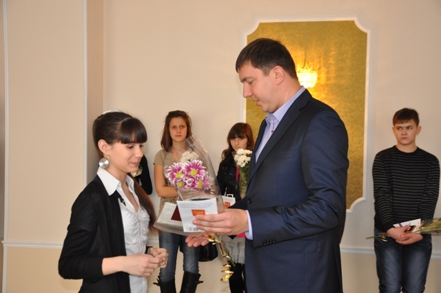 Павел Серебряков вручает школьнице паспорт