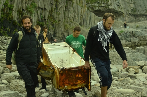 Волонтёры и сотрудники выносят холодильник, выброшенный морем, с мыса Столбчатый