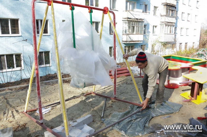 Рабочий устанавливает качели для новой детской площадки, Фото с места события из других источников