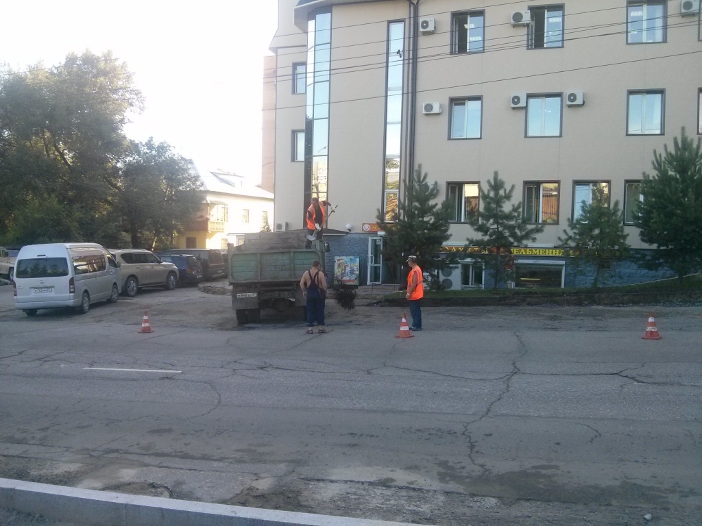 Строители разгружают новый асфальт и заделывают им ямы на дороге, Фото с места события собственное