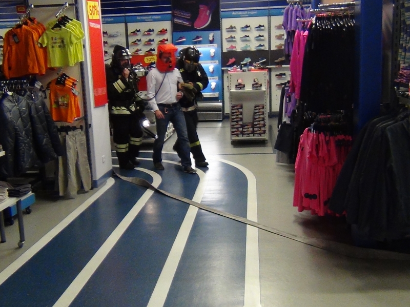 Огнеборцы выводят человека, оставшегося в очаге пожара