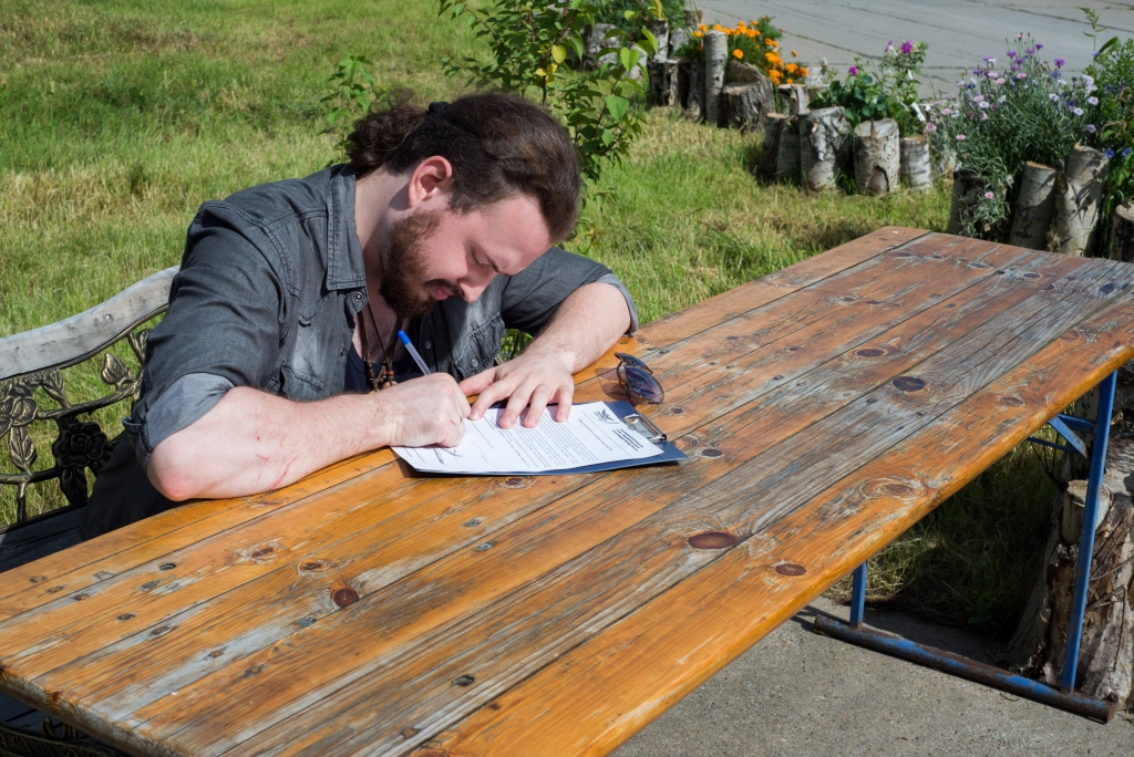 Евгений Никитенко подписывает документ о том, что знаком с правилами полета