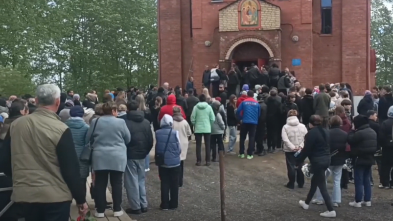 Девушка упала в обморок на церемонии прощания с жертвами резни в Байкальске скриншот видео ТАСС